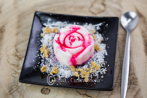 Malabi desert on a black plate, decorated with slices of nuts an