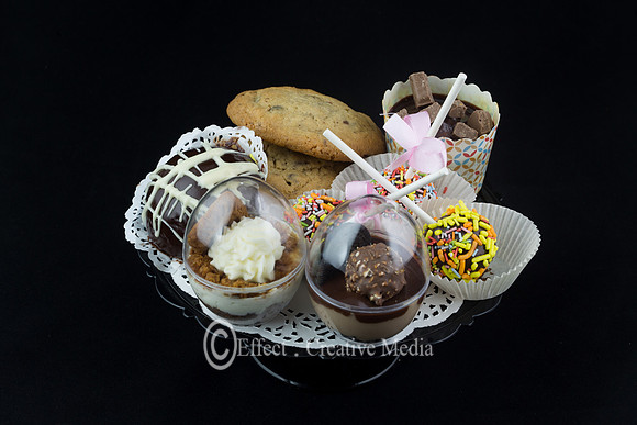 vraity of  chocolate cakes and cookies on a plat, black backgrou